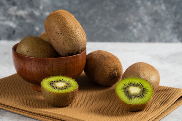 Bowl with delicious kiwi fruits on a brown tablecloth