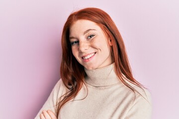 Obraz premium Young red head girl wearing turtleneck sweater happy face smiling with crossed arms looking at the camera. positive person.