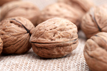 Close-up walnuts lie on a burlap.