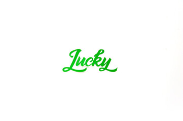 Lucky lettering on white background. Saint Patricks day greeting card. Space for text. Soft focus. Top view.
