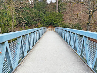 A metal pedestrian bridge over the Reuss River below the hydroelectric dam and in the Bremgarten...