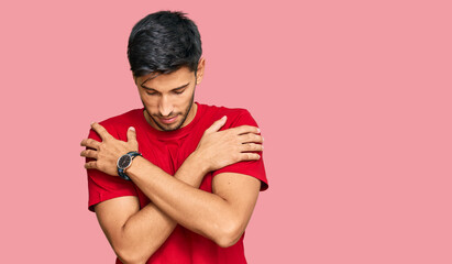 Fototapeta na wymiar Young handsome man wearing casual red tshirt hugging oneself happy and positive, smiling confident. self love and self care
