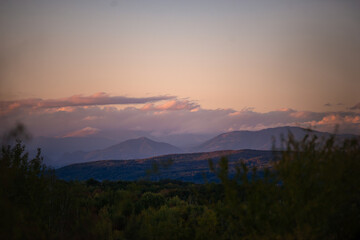 Fototapeta premium fall landscape overlooking the horizon where the ridges of the high mountains can be seen. high hills full of dense forests at sunset