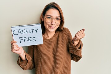 Young caucasian woman holding cruelty free message paper screaming proud, celebrating victory and...