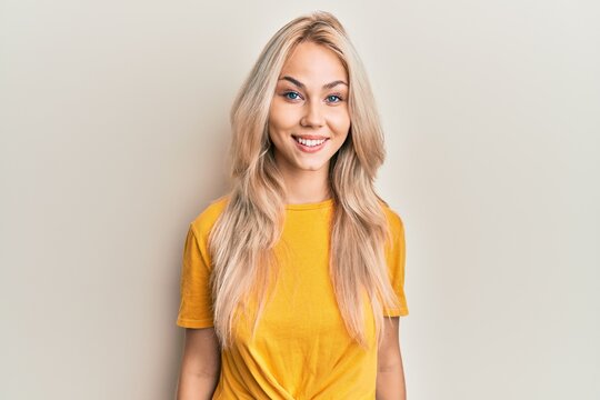 Beautiful caucasian blonde girl wearing casual tshirt with a happy and cool smile on face. lucky person.