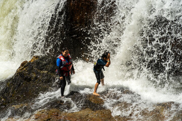 Obraz premium Tourist enjoys the beautiful of Lasir waterfall, Kenyir Lake, Terengganu. Lasir waterfall also known as Air Terjun Lasir.
