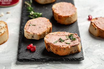 Meat liver pate on toasted bread with fruit seeds and spice herb. Top view.