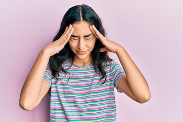 Hispanic teenager girl with dental braces wearing casual clothes with hand on head for pain in head...