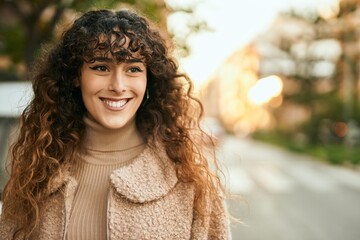 Young hispanic woman smiling happy standing at the city