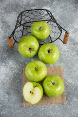Metal bucket of fresh green apples on marble background