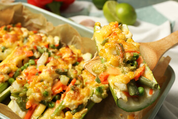 Baked stuffed zucchini on wooden spatula, closeup