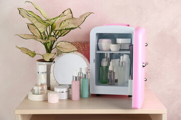 Cosmetics refrigerator and skin care products on table