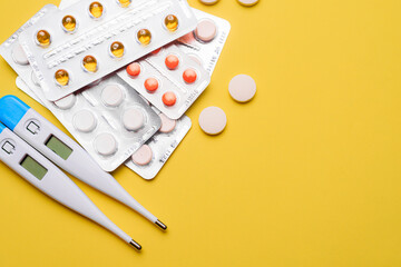 A pile of pills on a yellow background . Treatment and prevention. Article about the purpose of treatment. A cure for the disease. Pills in a blister. Lots of medicine. Copy space