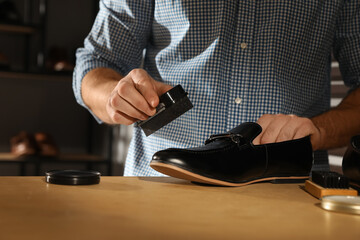 Master taking care of shoes in his workshop, closeup