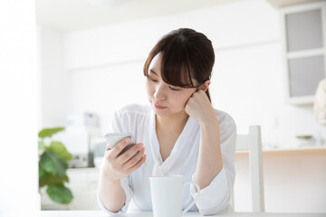 女性　スマホ　悩む　検索　キッチン