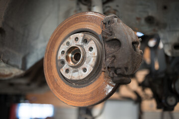 Old and rusty car's suspension parts. Rusted disc brake and caliper on the car. Automotive industry...