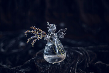miniature decorative vase on black background, bottle vase in the shape of an angel with dry lavender, cute glass vase with lavender flowers, glass angel with wings