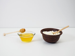 Healthy farmer's cottage cheese in earthenware and natural flower honey in a glass bowl. Natural dairy products, diet food, sugar substitution, benefits and vitamins