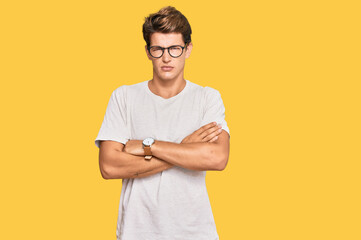 Handsome caucasian man wearing casual clothes and glasses skeptic and nervous, disapproving expression on face with crossed arms. negative person.