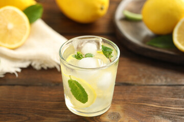 Cool freshly made lemonade in glass on wooden table, closeup