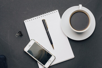 the dark background a Cup of coffee office Notepad handle the view from the top