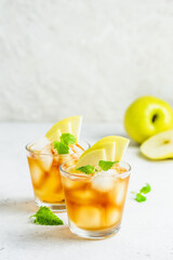 Spicy summer apple cocktail, apple iced tea in glasses. Space for text.