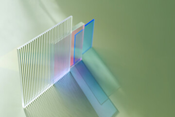 Ribbed and multicolored glass on a green background. The light travels through different acrylic sheets