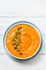 Spice carrot pumpkin soup in a bowl. Top view, flat lay, space for text.