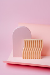 Pink arch  and wooden plate with waves  on a paper background. Stylish background with various ...