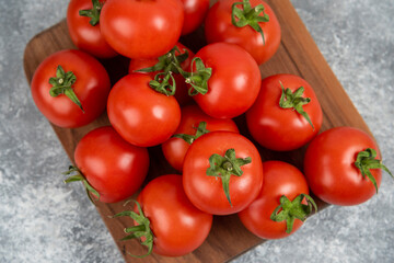 Bunch of red fresh tomatoes on wooden cutting board