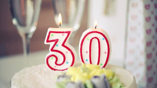 Birthday candle as number thirty 30 on top of sweet cake on the table, 30th birthday, toned video
