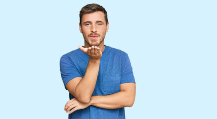Fototapeta premium Handsome caucasian man wearing casual clothes looking at the camera blowing a kiss with hand on air being lovely and sexy. love expression.