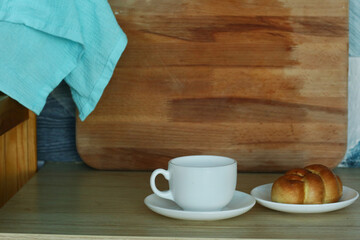 kitchen closeup fragment with croissant and tea cup on table