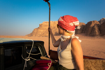 Woman riding a pickup truck in the jordanian desert