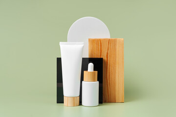 Cream tube and dropper mockup with decoration and geometrical forms on green background. Natural skincare beauty product for branding and packaging presentation.