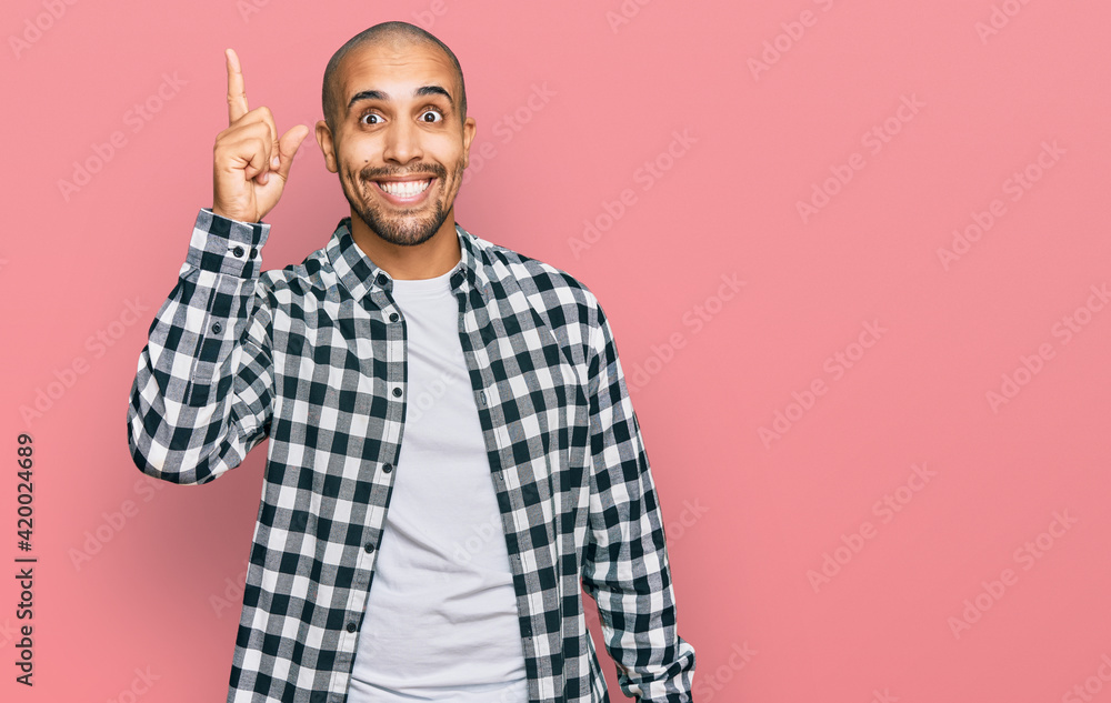 Canvas Prints Hispanic adult man wearing casual clothes pointing finger up with successful idea. exited and happy. number one.