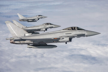 RAF Typhoon Fighter Jets. Armed Supersonic interceptors  flying in formation high above the clouds....