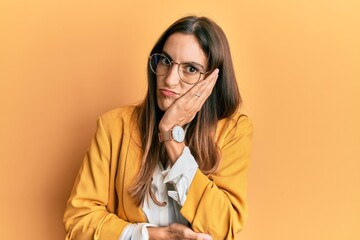 Young beautiful woman wearing business style and glasses thinking looking tired and bored with depression problems with crossed arms.