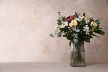 Beautiful bouquet with roses on wooden table. Space for text