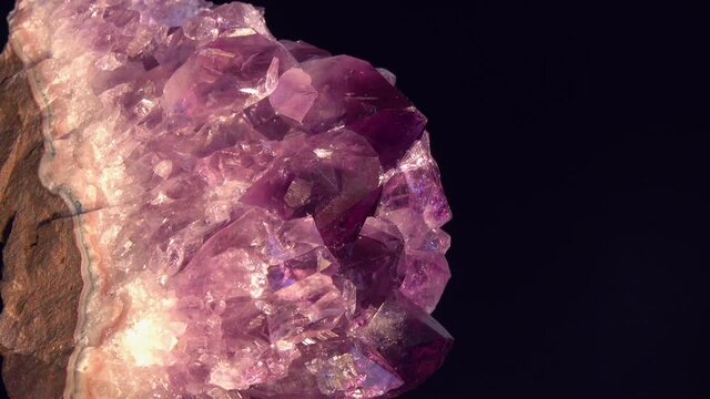Druse of Violet Amethyst Crystals. Footage of Violet Crystal Stone macro mineral against a dark background. Crystal druse rotation in the frame