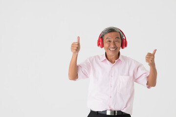 Portrait of a good-looking full of energy and active senior older Asian man holding and wearing red headphone and listening to music with joyfully and happy face and deep emotion on white background.