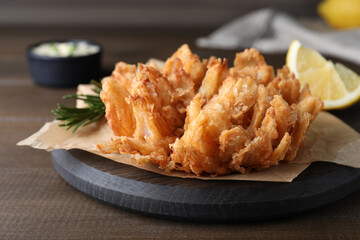 Fried blooming onion served on wooden table, closeup