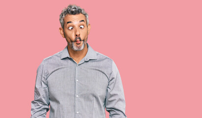 Middle age grey-haired man wearing casual clothes making fish face with lips, crazy and comical gesture. funny expression.
