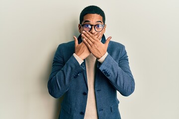 Young handsome hispanic man wearing elegant clothes and glasses shocked covering mouth with hands...