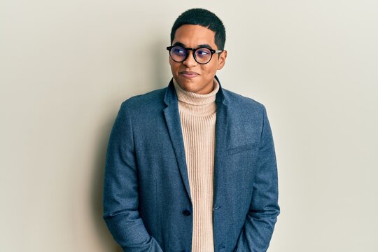 Young handsome hispanic man wearing elegant clothes and glasses smiling looking to the side and staring away thinking.