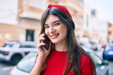 Young caucasian woman smiling happy talking on the smartphone walking at the city.