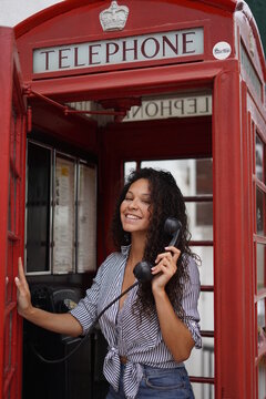 Modelo brasileña hablando desde una cabina telefonica en londres