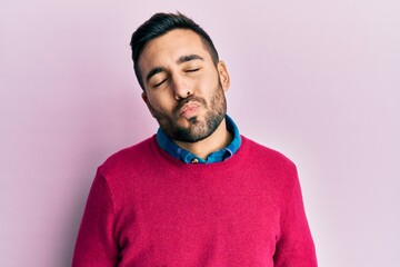 Young hispanic man wearing casual clothes looking at the camera blowing a kiss on air being lovely and sexy. love expression.