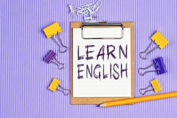 The words Learn English written on a white notebook. Work and study concept