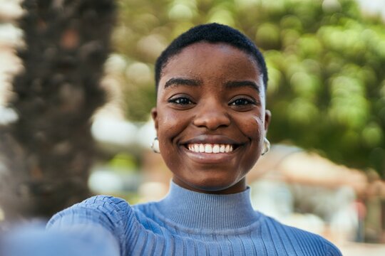Young african american woman smiling happy making selfie by the camera at the city.